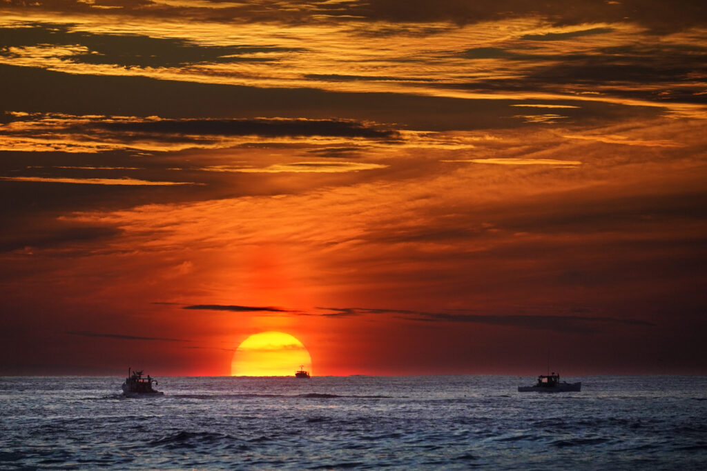 Deep sea mining permits may be coming soon. What are they and what might happen? PHOTO FILE - The sun rises over fishing boats in the Atlantic Ocean, Sept. 8, 2022, off of Kennebunkport, Maine. The United Nations body that regulates the world’s ocean floor is preparing to resume negotiations in July 2023, that could open the international seabed for mining, including for materials vital for the green energy transition. (AP Photo/Robert F. Bukaty, File)