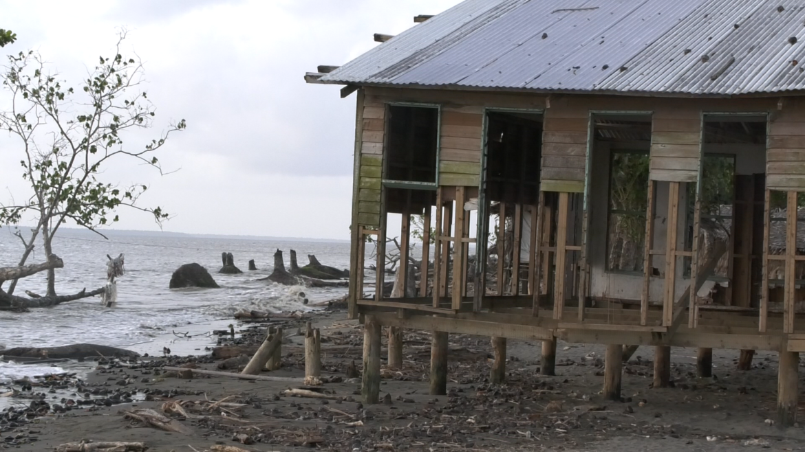 Old housing standing in front of a destroyed beach.