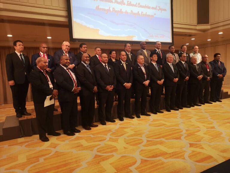 Country leaders in suits standing on a stage at PALM 10 meeting where Fukushima Radioactive waste is being addressed.