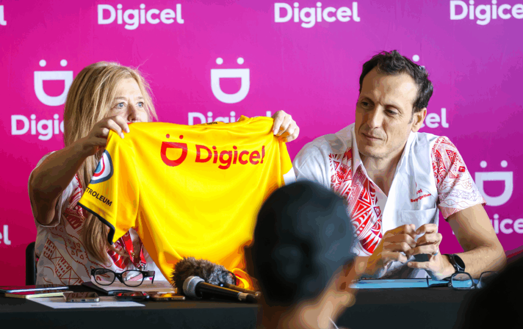Digcel PNG Senior VP and Chief Sales officer Lorna McPherson shows PNG Media the Digicel branding on the back of PNG LNG Kumul Jersey. Beside her is Digicel CEO Tarik Boduiaf.