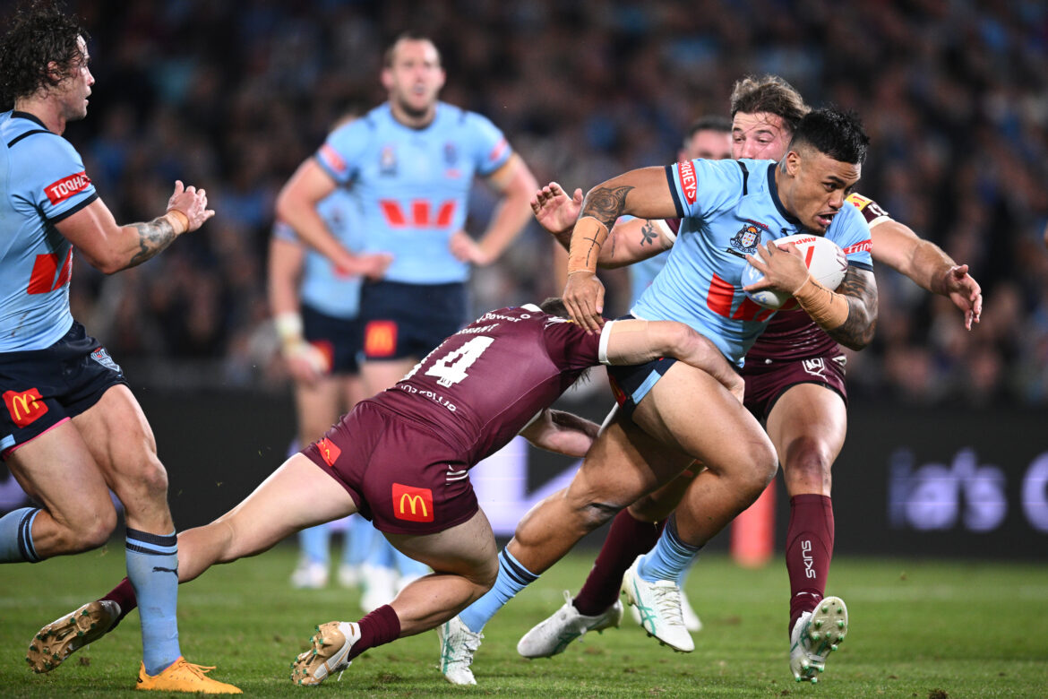 Spencer Leniu of the Blues is tackled by Harry Grant and Patrick Carrigan of the Maroons during Game 1 of the State of Origin 2024 between the Queensland Maroons and the New South Wales Blues at Accor Stadium in Sydney, Wednesday, June 5, 2024.
