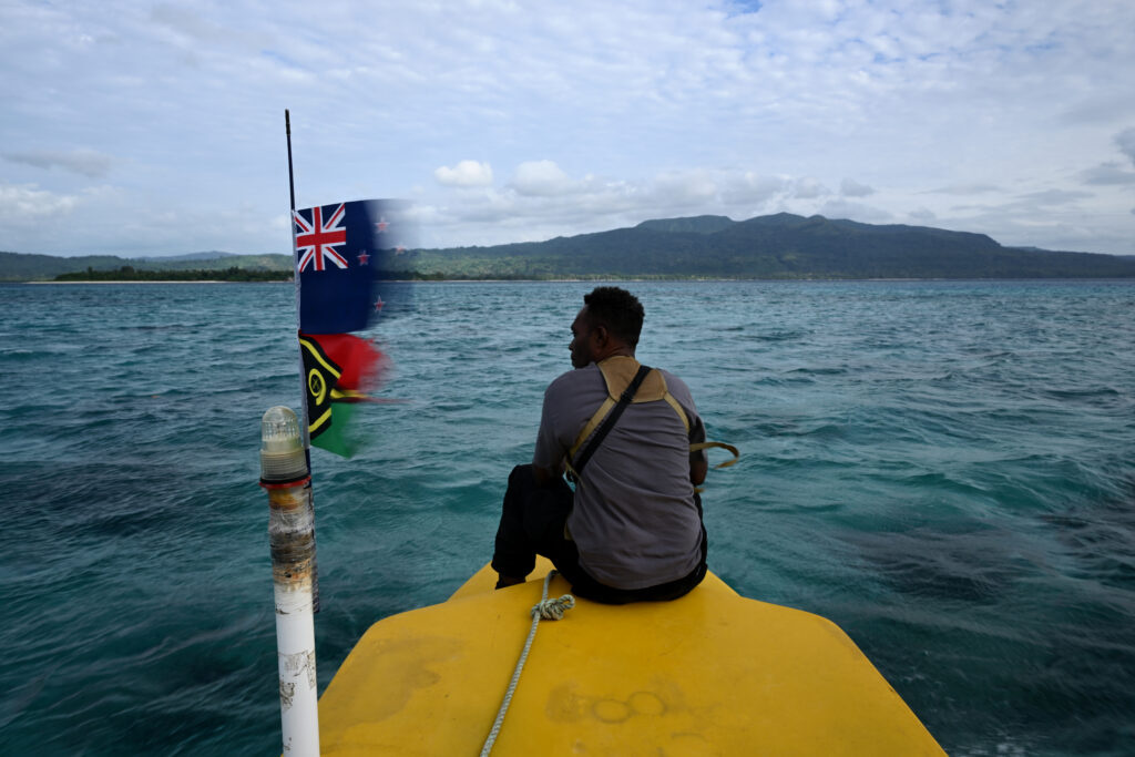 The long, winding road to a climate-resilient Pacific Young Melanesian man sitting on a floater looking out at sea.
