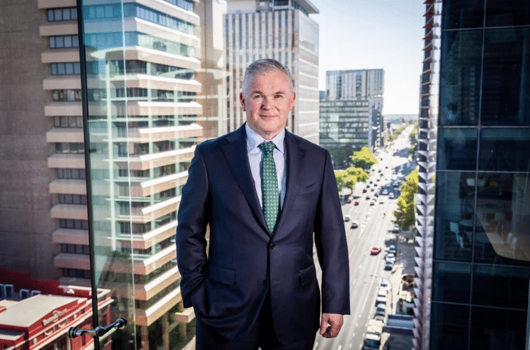 Silver haired caucasian man earing a navy blue suit and tie