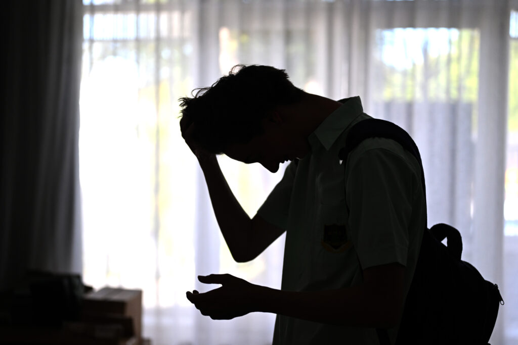 A silhouette of a male high school student to illustrate stress and mental health issues