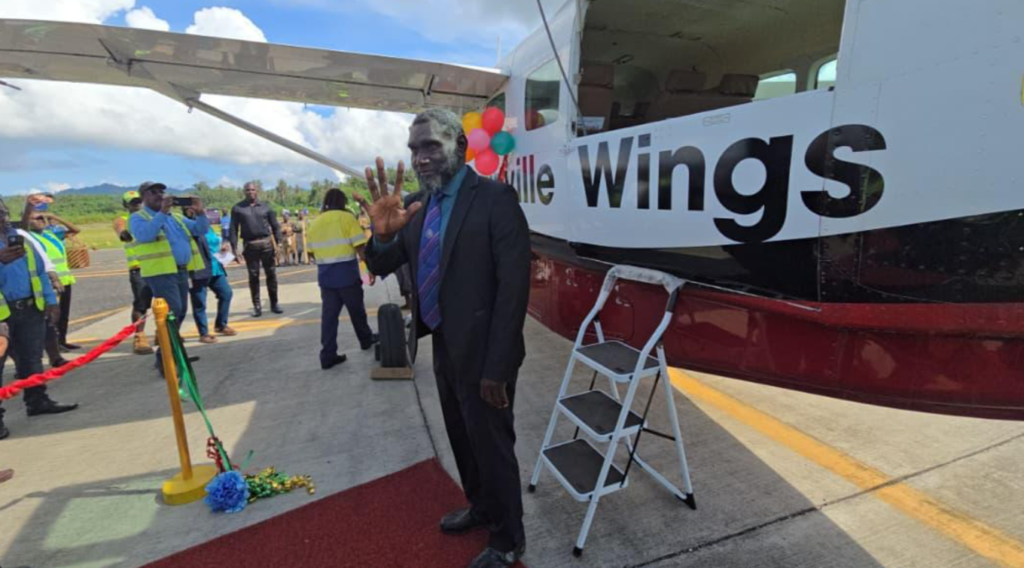 Bougainville President, Ishmael Toroama standing next to the aircraft, Bougainville Wings.