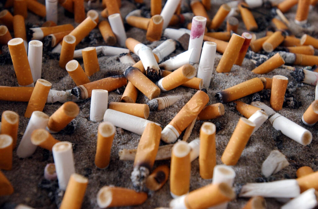Smokers cigarette butts in a ashtray bin.